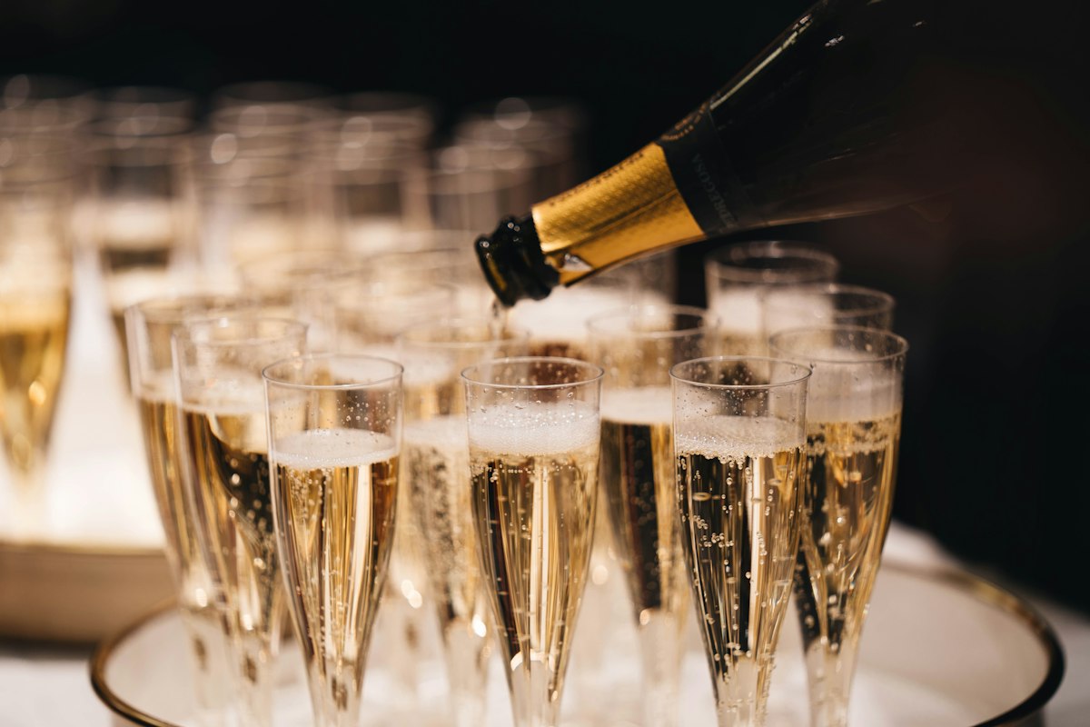 Champagne being poured into a tray of crystal flutes
