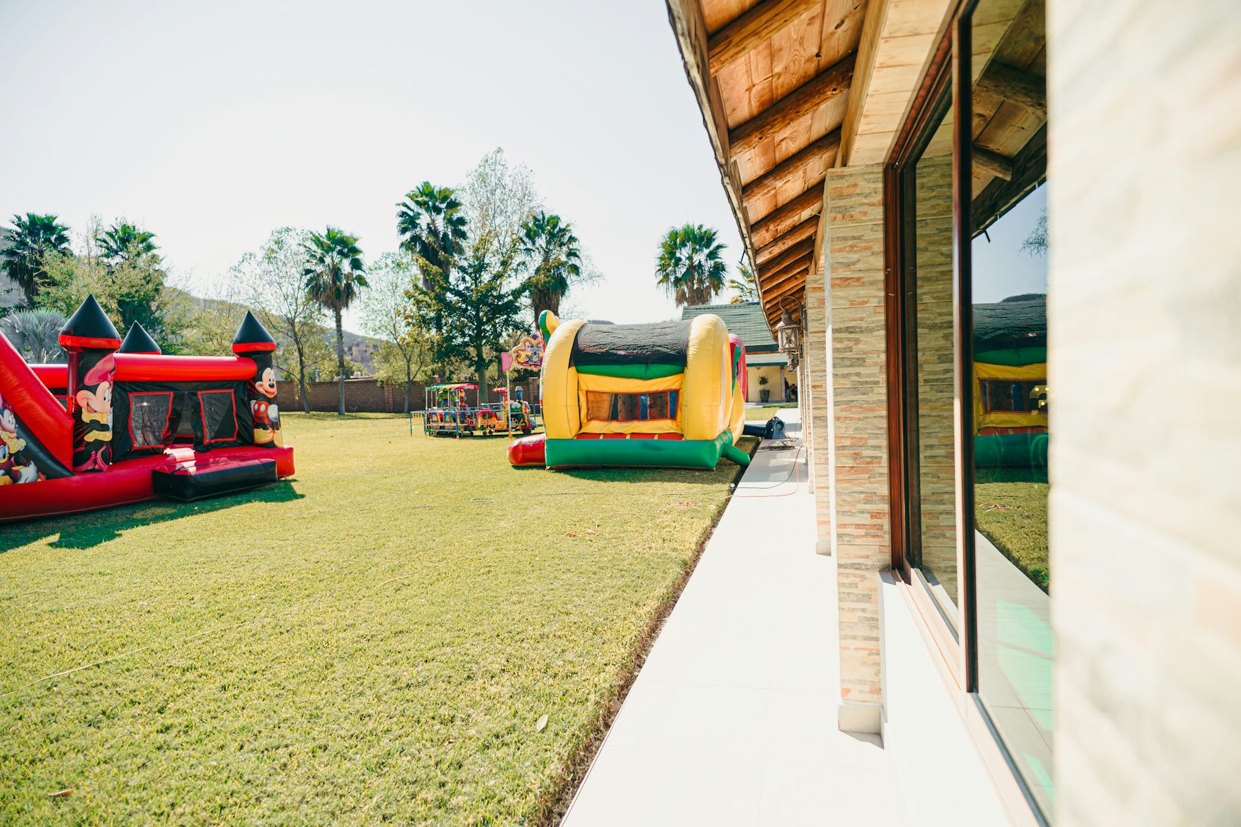 Two inflatable bounce houses on a sunny lawn