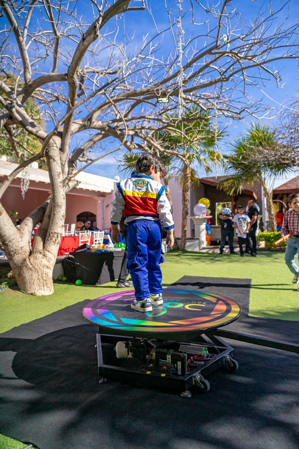 A guest standing on a 360 camera platform at an outdoor party
