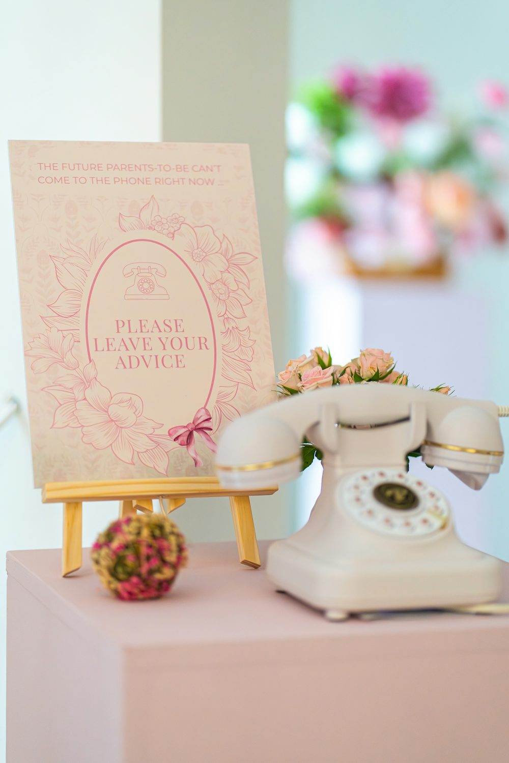 A white vintage telephone beside a sign inviting guests to leave their advice