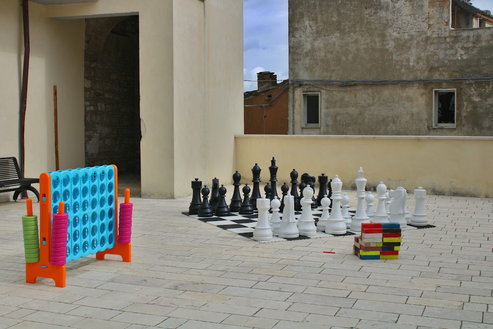 Giant chess pieces and a connect four game on a patio